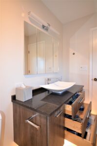 Remodeled bathroom with cabinet storage in the woodgrain vanity.