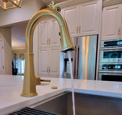 Kitchen remodel with a gold sink faucet and gold hardware