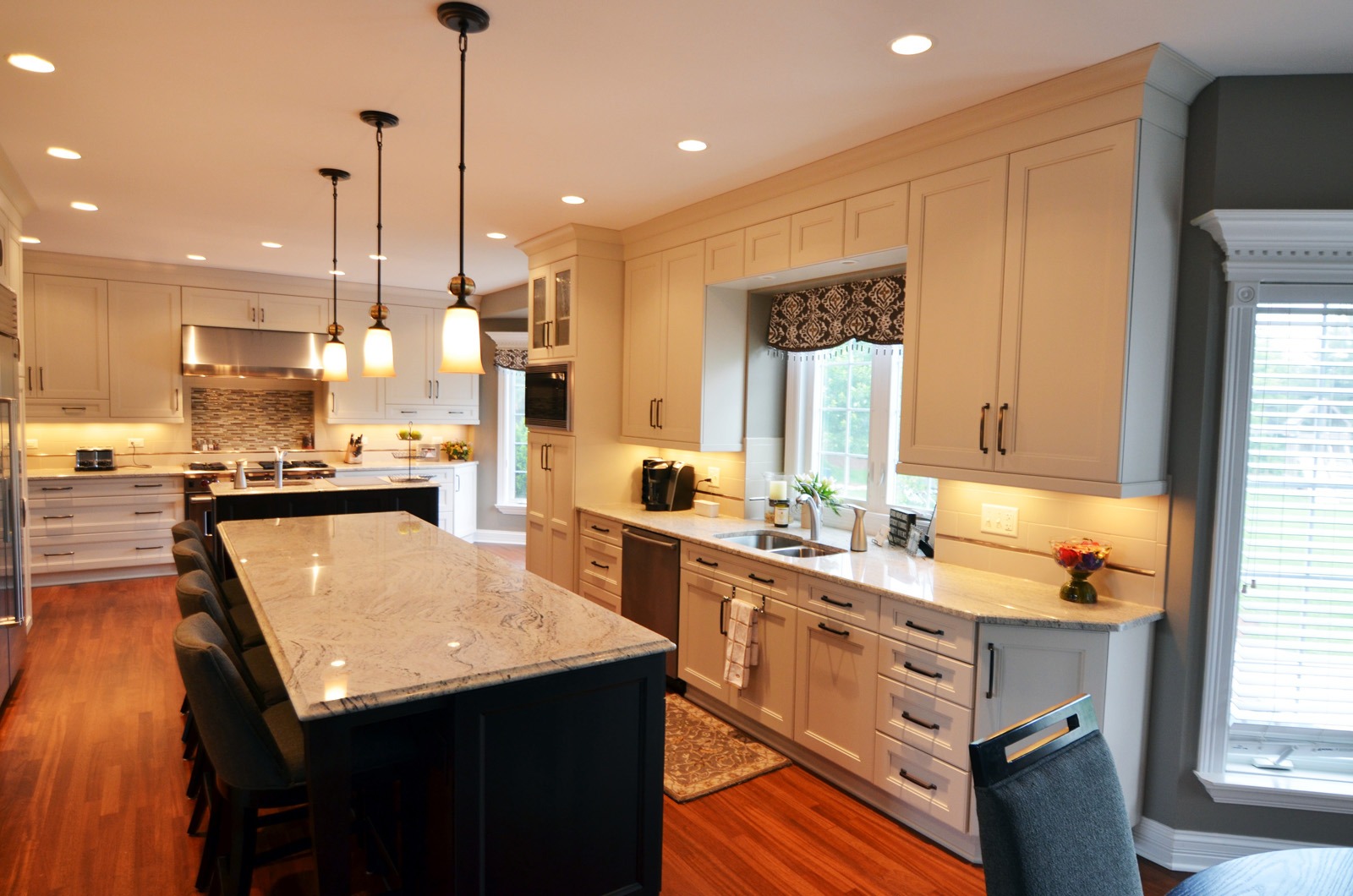 A custom kitchen with a bump-out window and marble countertops