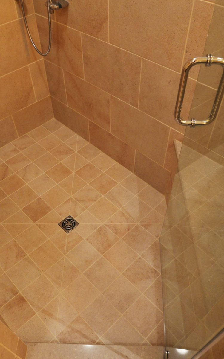Bathroom remodeling in Naperville, IL. Shower floor tile detail with angled door.