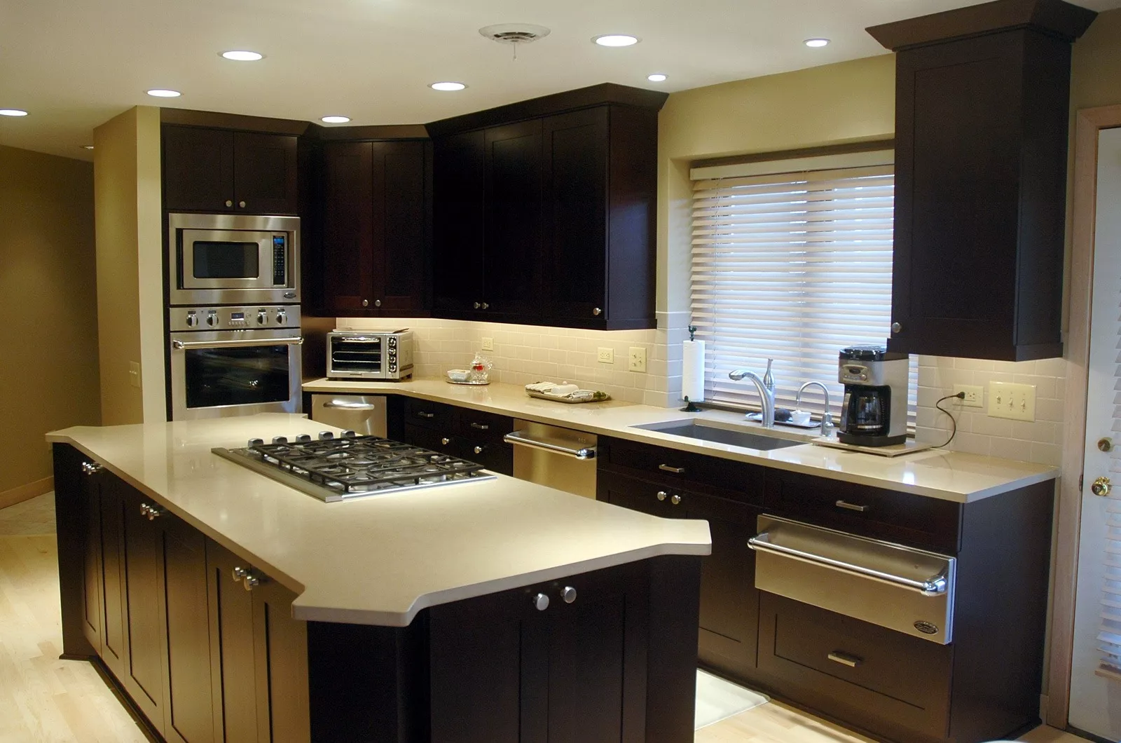 This remodeled kitchen has modern dark cabinets and marble countertops