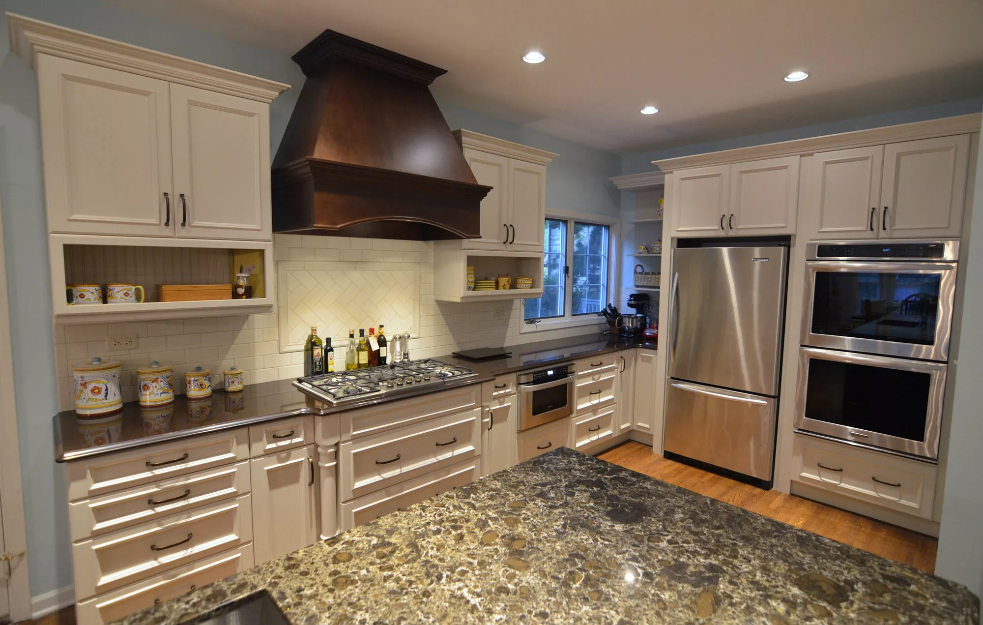 kitchen renovation hooded vent stainless steel appliances stone countertops the kitchen master