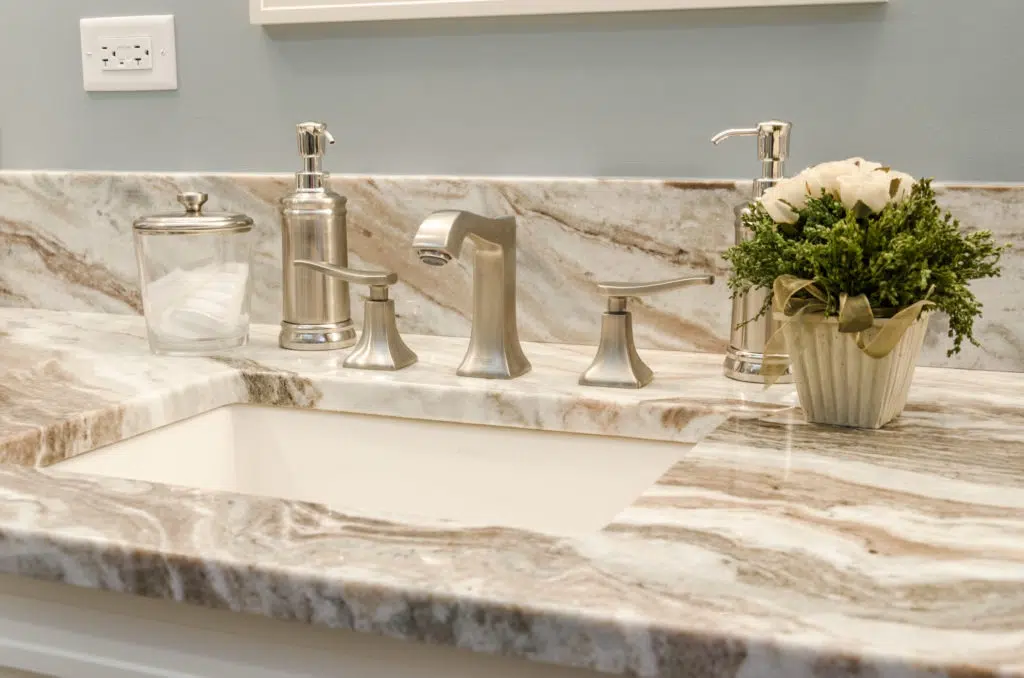 close up of quartz vanity kitchen renovation with chrome finishes small plant glass storage cup