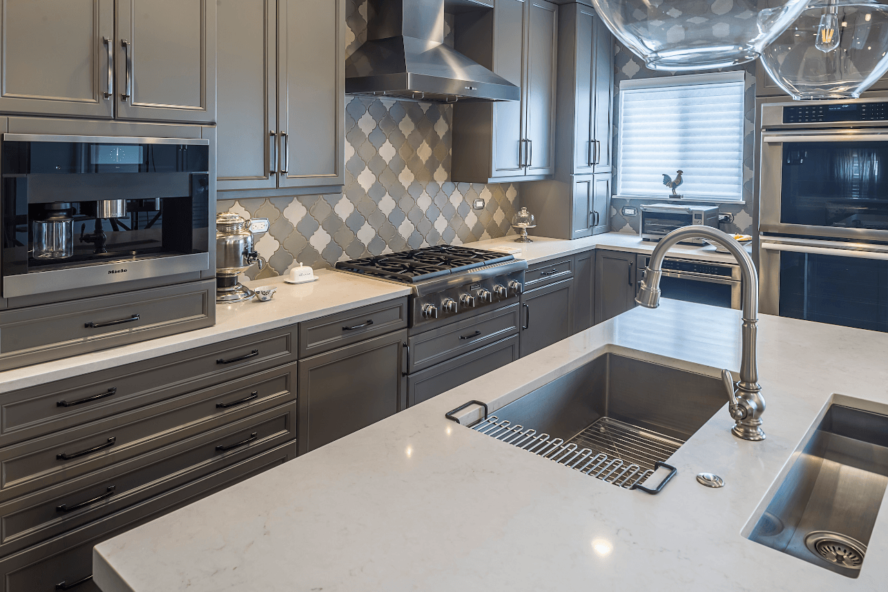 kitchen remodel hooded vent patterned backsplash tile grey cabinets stone countertops