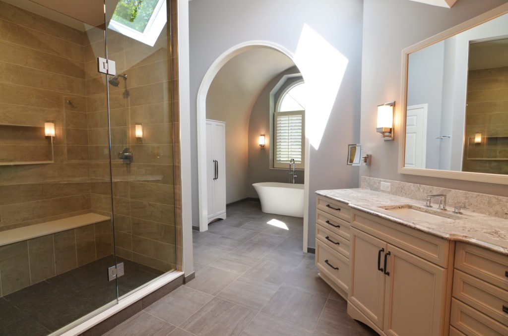 master bathroom renovation arched entryway large glass shower with bench light quartz vanity