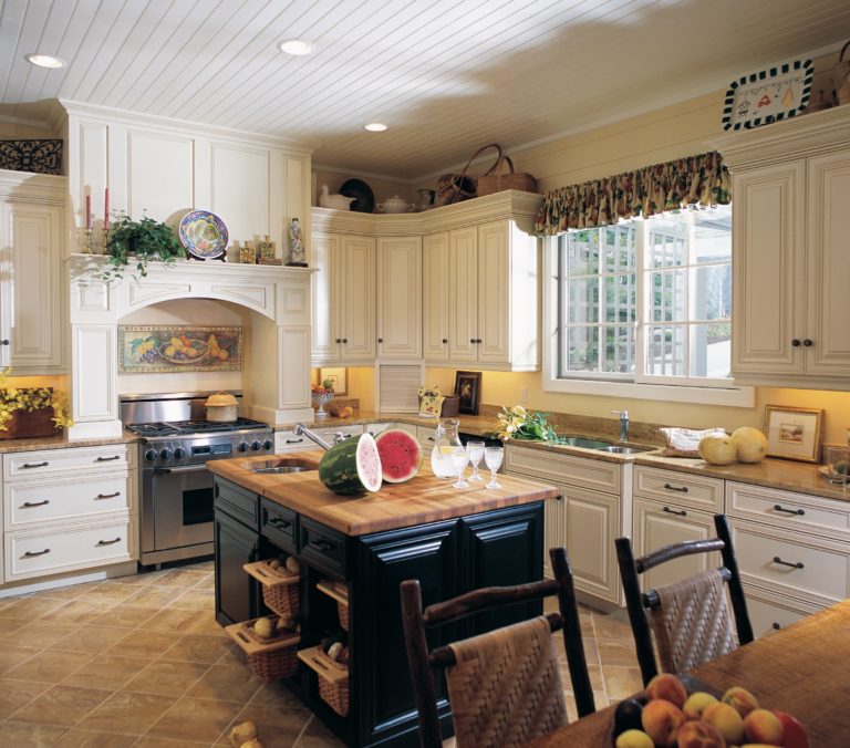 traditional kitchen renovation white cabinetry black island with cut watermelon and lemonade