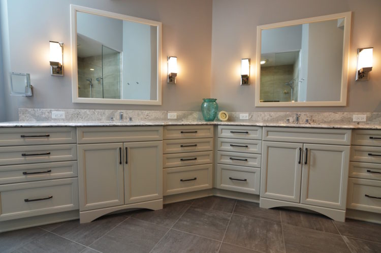bathroom with two vanities cream cabinets black fixtures patterned countertops two mirrors