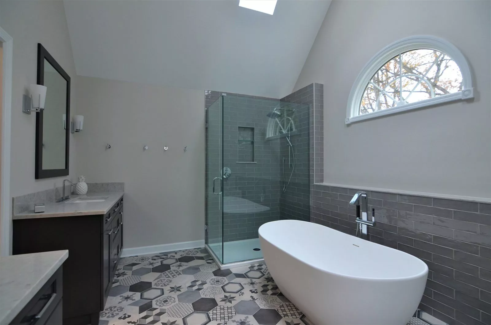 Bathroom with free-standing bathtub, glass corner shower, and sink