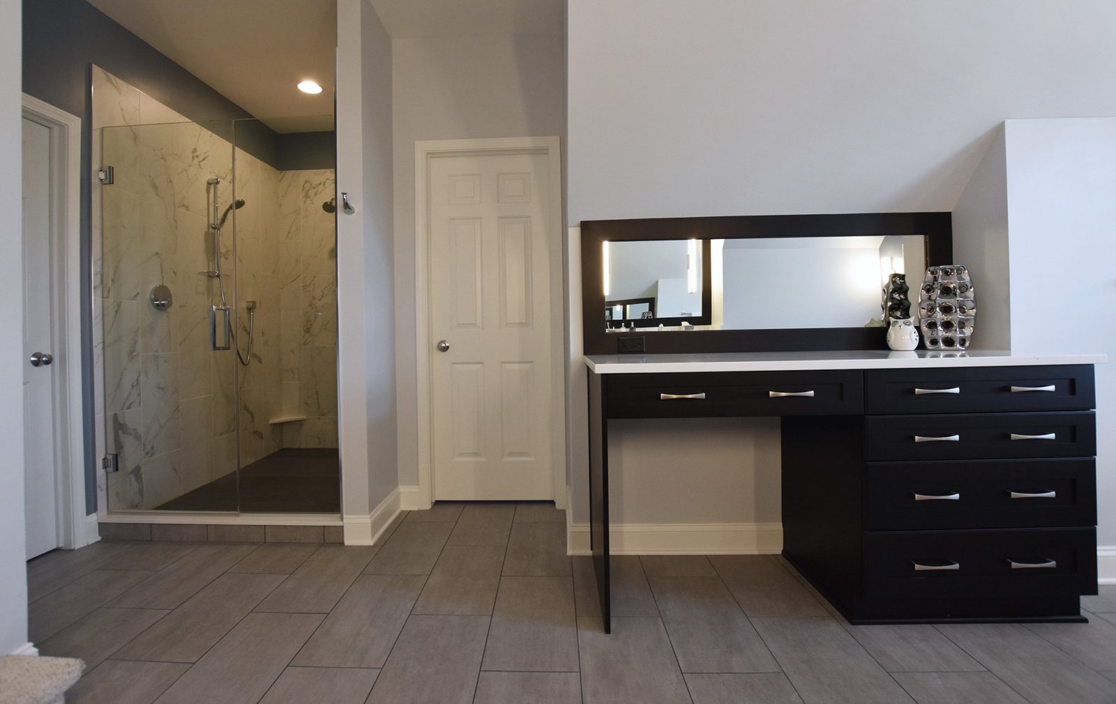 Bathroom with a countertop along one wall and walled-in shower in a corner