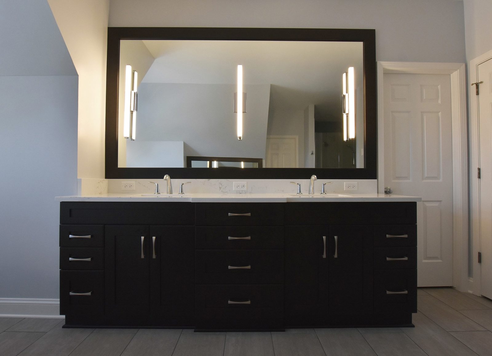 Connected backroom sinks with large mirror above, cabinets and drawers below