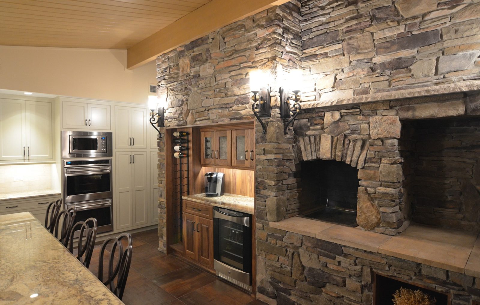 Kitchen with cabinets, drawers, appliances, kitchen table and chairs, stonework wall with stone oven