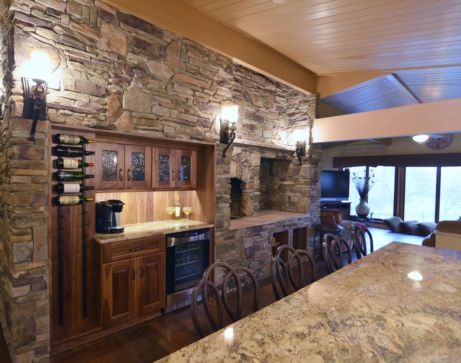 Kitchen with a stonework wall and stone oven, wine cooler, drawers, cabinets, and small countertop