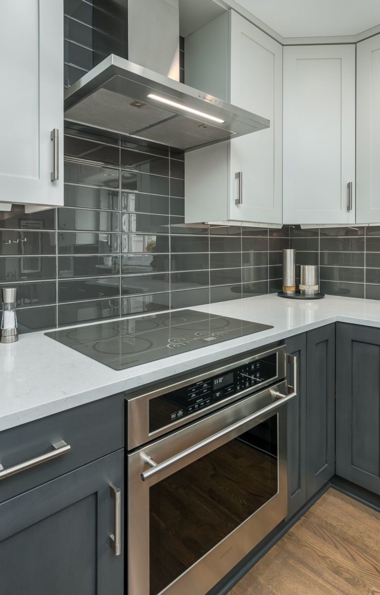 Kitchen counter with oven, electric stove, and hood vent