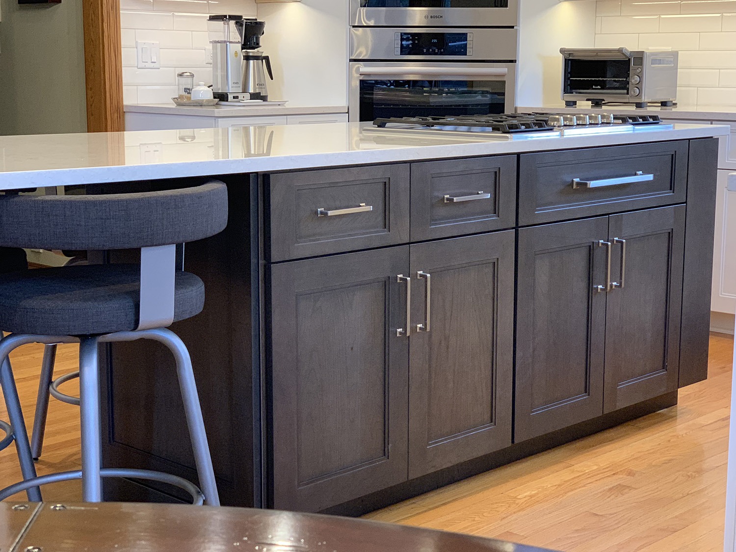 kitchen renovation white stone coutnertop brwon cabinetry chrome hardware