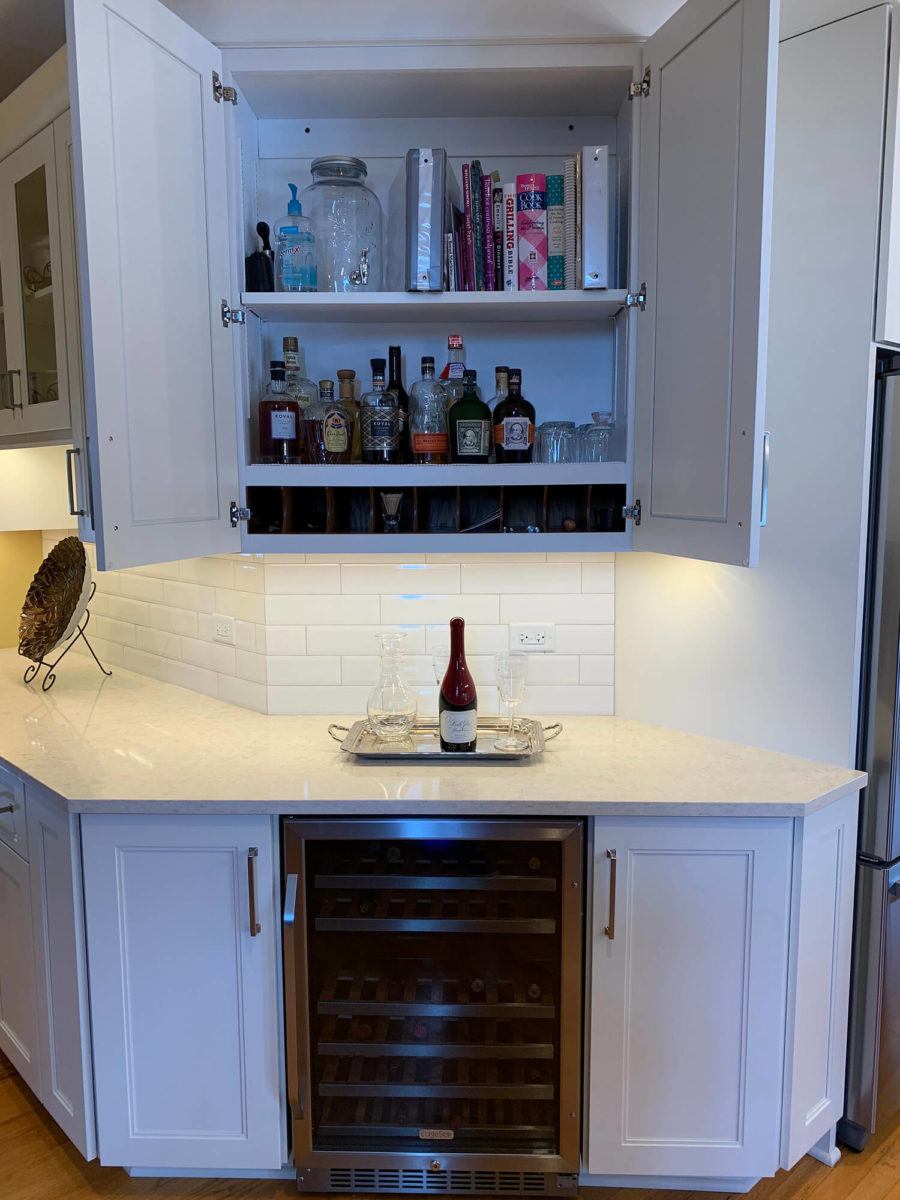 white cabinetry open wine glasses books wine cooler under cabinet lighting