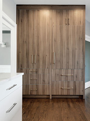 Large free-standing pantry containing cabinets and drawers standing in a room