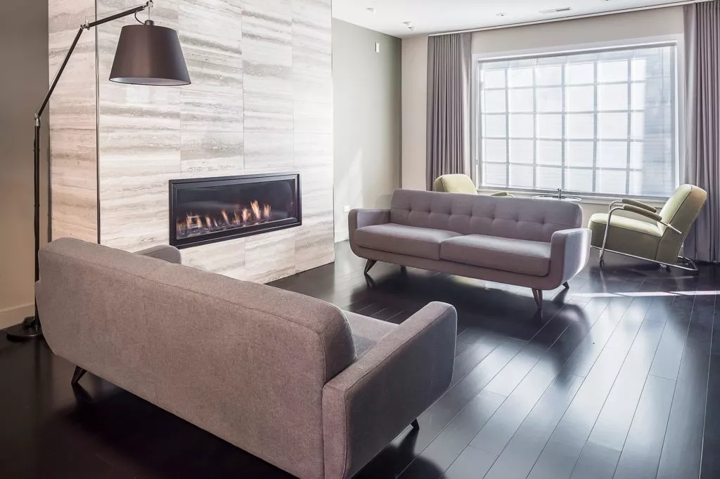 modern hotel room remodel two grey love seats gas fireplace tile feature wall the kitchen master