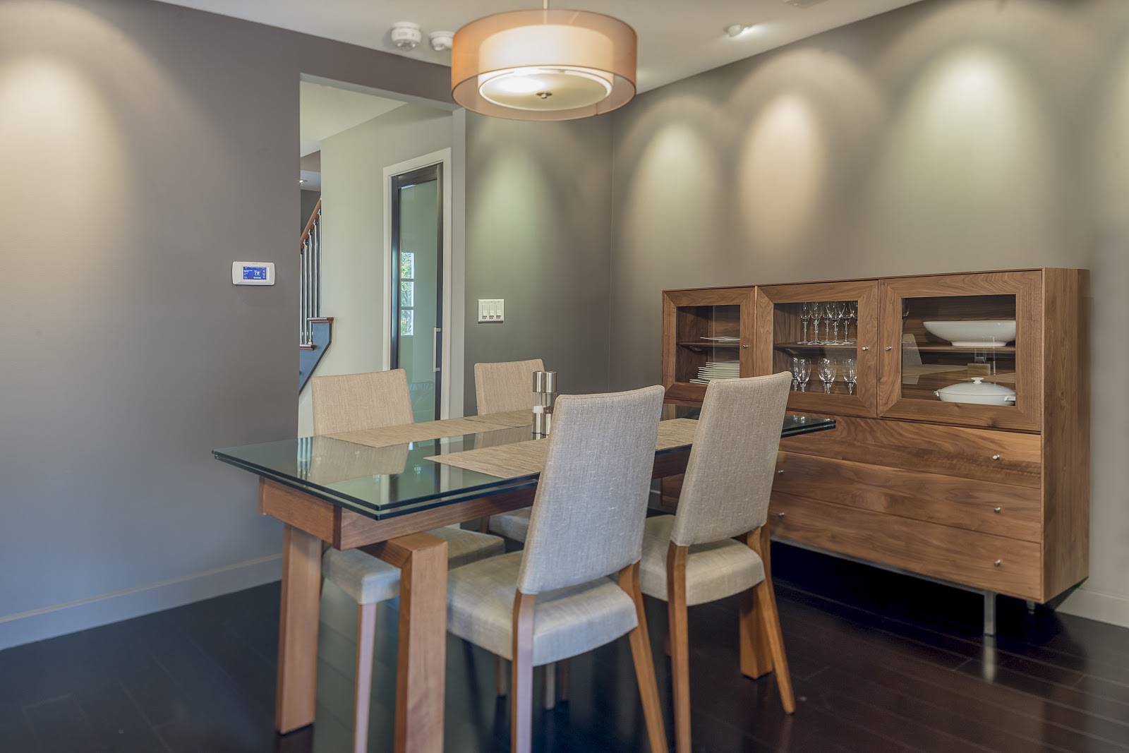 Dining room with table, piece of furniture with cabinets and drawers holding plates and glasses