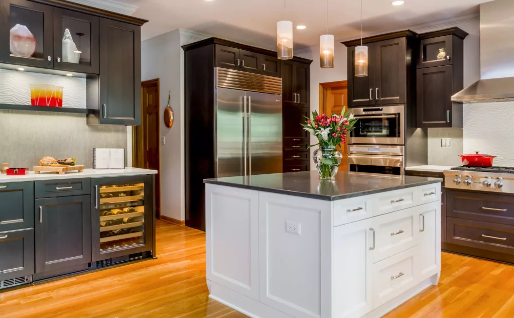 dark toned kitchen renovation white island marble countertops hooded vent glass cabinetry