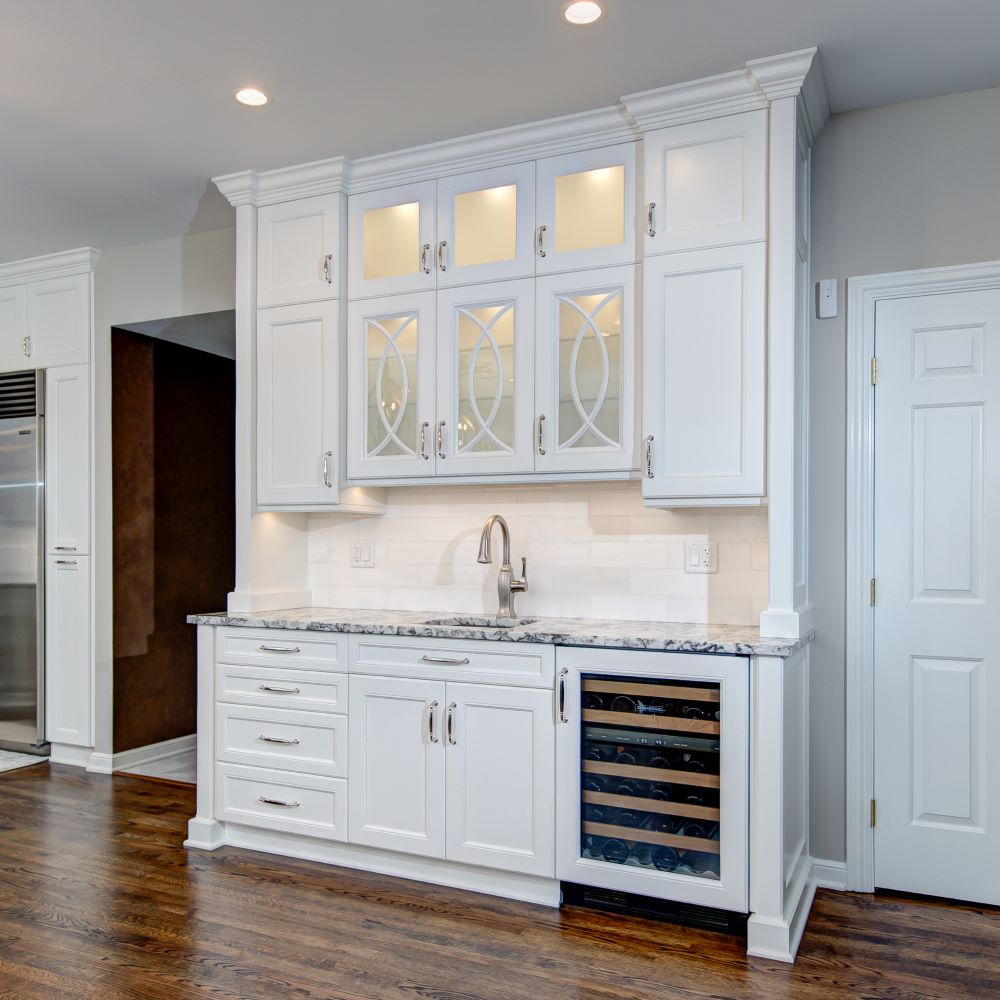butler's kitchen area white cabinetry wine cooler chrome sink granite countertops crown molding