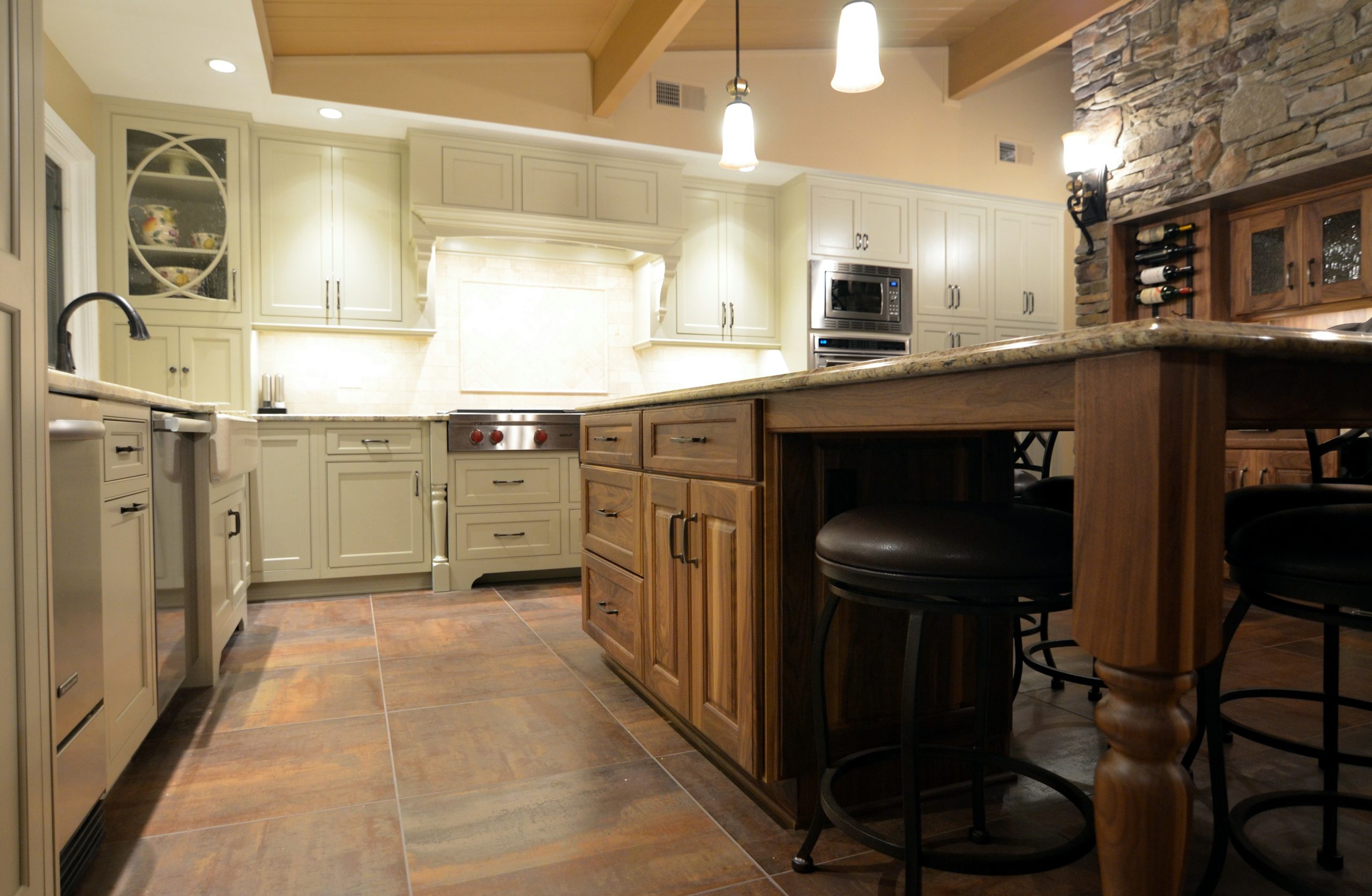 kitchen remodel exposed ceiling beams white cabinetry stone fireplace wine wall large island